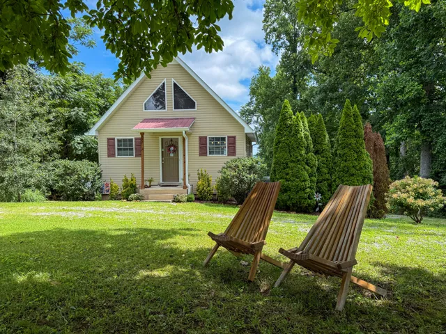 a view of a house with a yard and sitting area