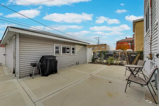 a view of a chairs and table in the back yard