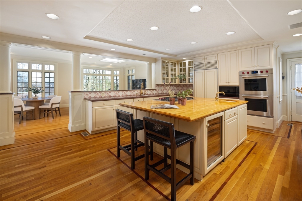 116 Chestnut Hill Road Newton, MA 02467 - Photo 10 of 18 a kitchen with stainless steel appliances kitchen island granite countertop a stove a sink a dining table and chairs
