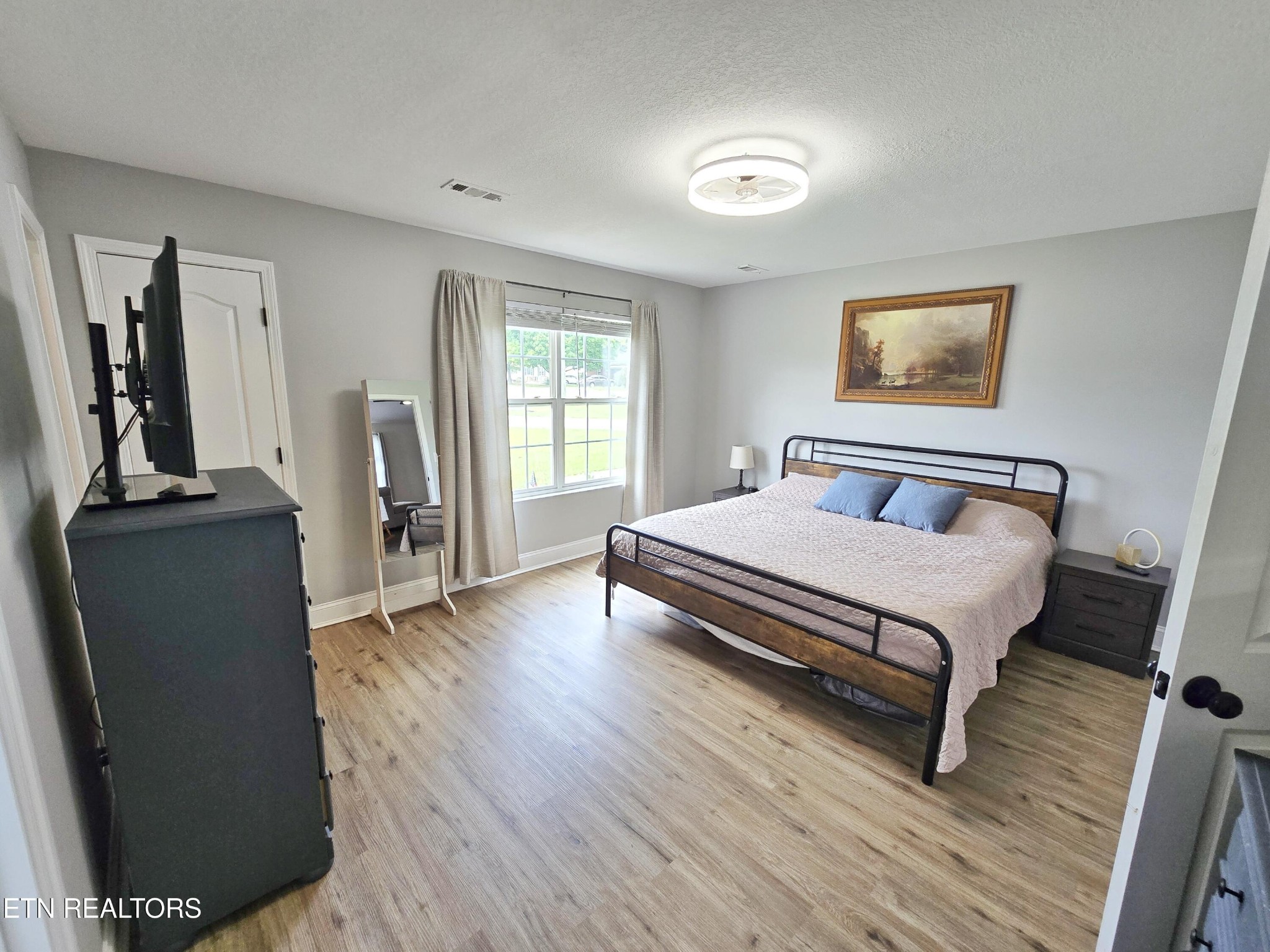 181 Sunset Road Clinton, TN 37716 - Photo 12 of 42 a bedroom with a bed and wooden floor