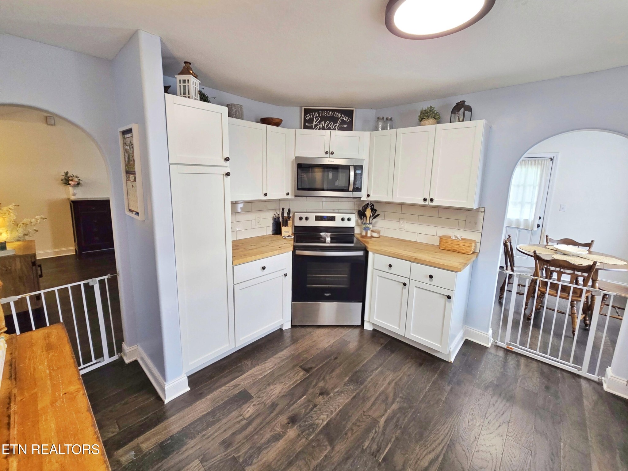 181 Sunset Road Clinton, TN 37716 - Photo 9 of 42 a kitchen with stainless steel appliances a white stove top oven a sink a refrigerator and white cabinets with wooden floor