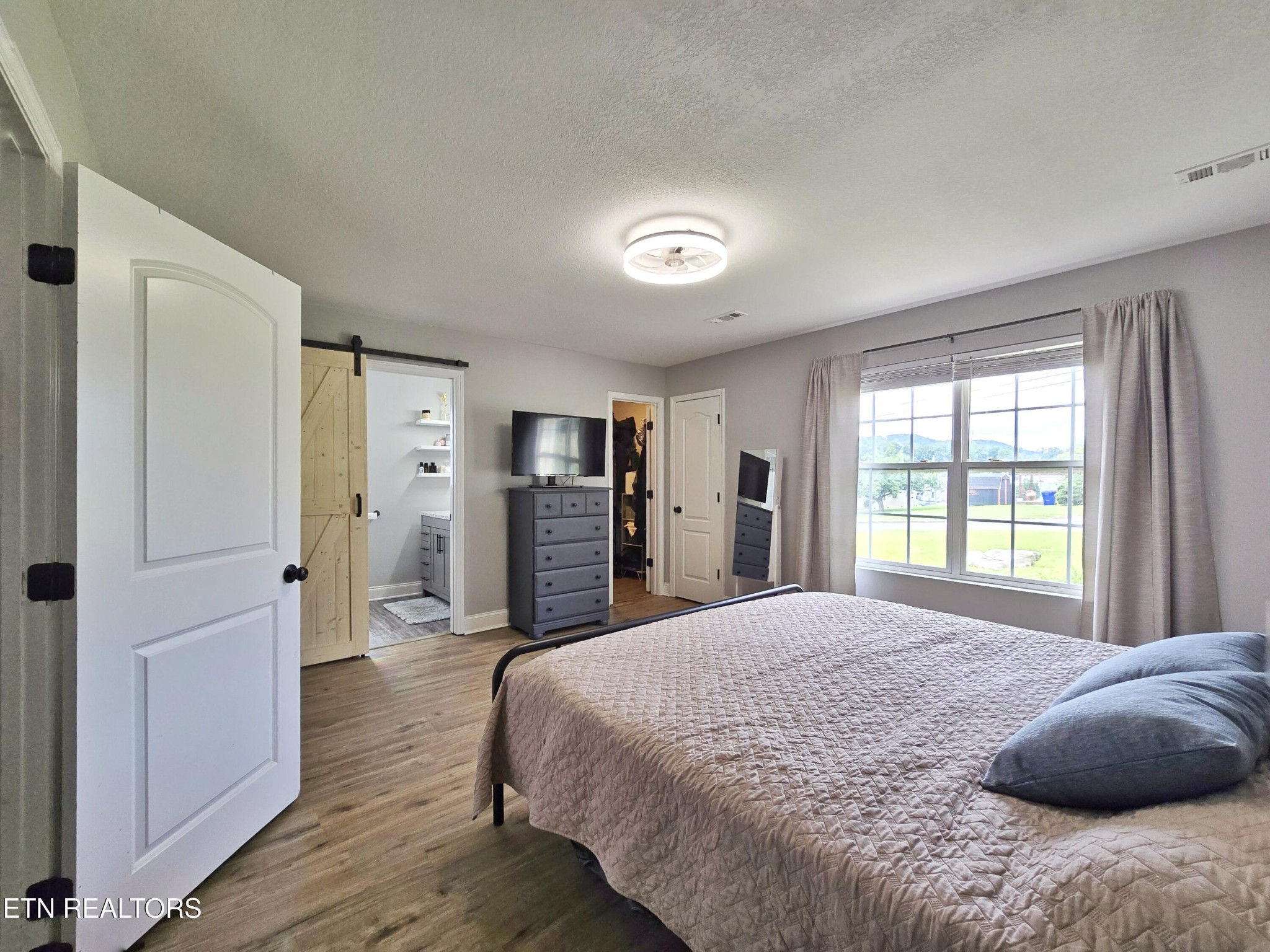 181 Sunset Road Clinton, TN 37716 - Photo 10 of 42 a spacious bedroom with a bed and wooden floor