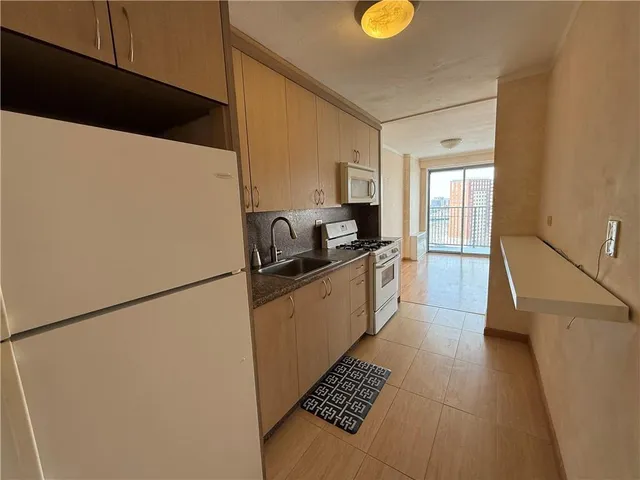 a kitchen with a refrigerator and a stove top oven