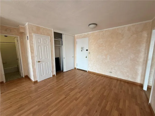a view of empty room with wooden floor and entryway