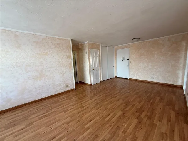 a view of empty room with wooden floor