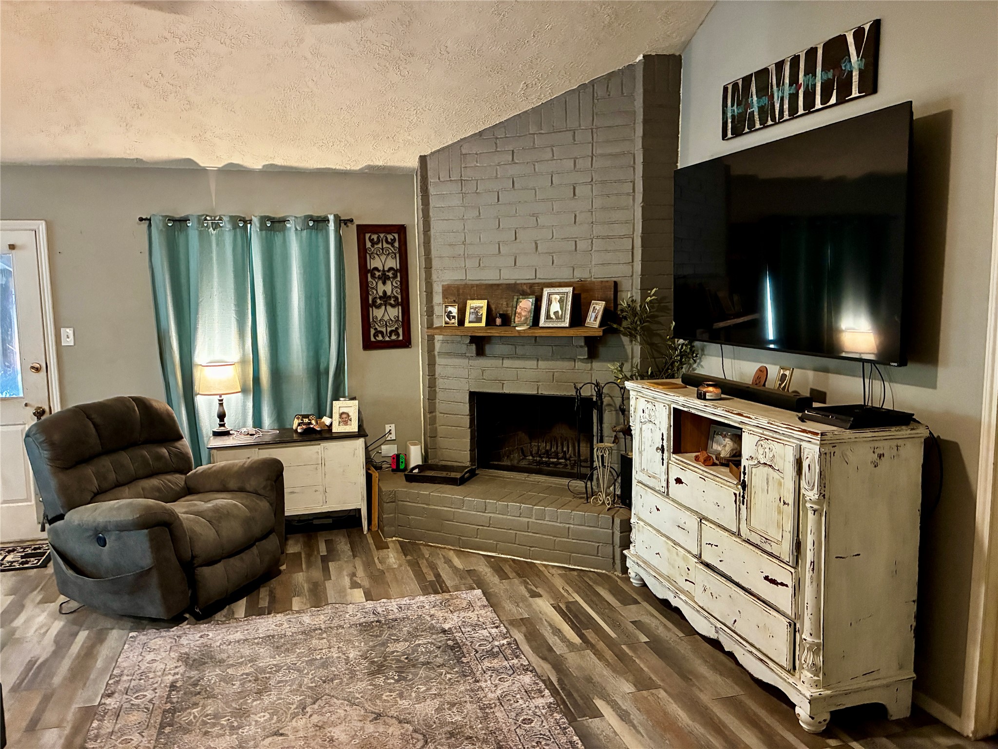 2 Sarita Road Angleton, TX 77515 - Photo 2 of 21 a living room with furniture a flat screen tv and a fireplace