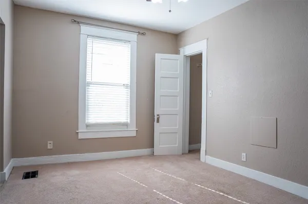 an empty room with windows and closet