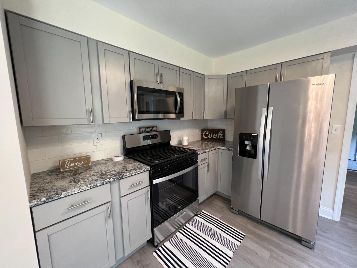 237 Krouser Drive Valparaiso, IN 46385 - Photo 8 of 31 a kitchen with granite countertop a refrigerator stove and sink