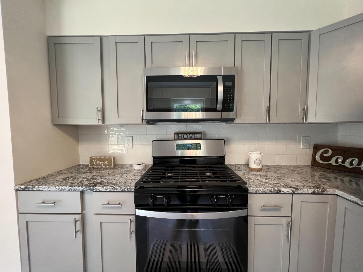 237 Krouser Drive Valparaiso, IN 46385 - Photo 10 of 31 a kitchen with granite countertop white cabinets and black appliances