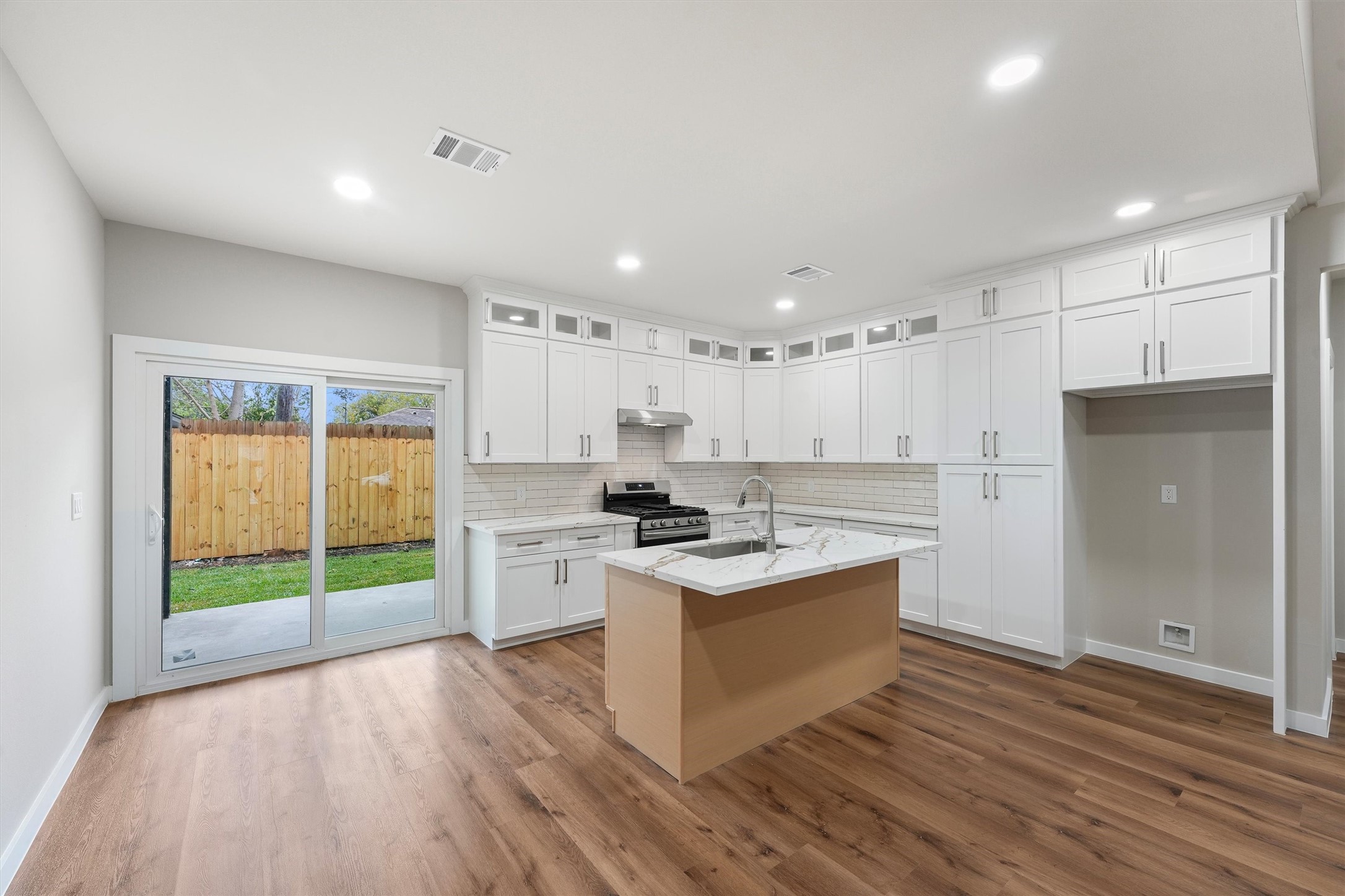 1208 Richard Avenue Pasadena, TX 77506 - Photo 11 of 27 a kitchen with a stove a refrigerator and a wooden floor