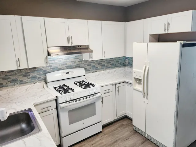 a white kitchen with a stove top oven