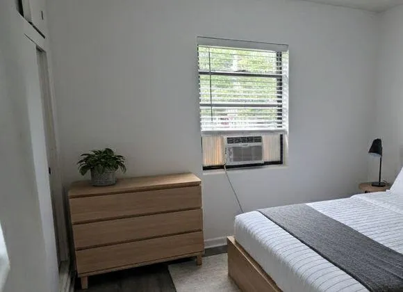 a bedroom with a bed and a window