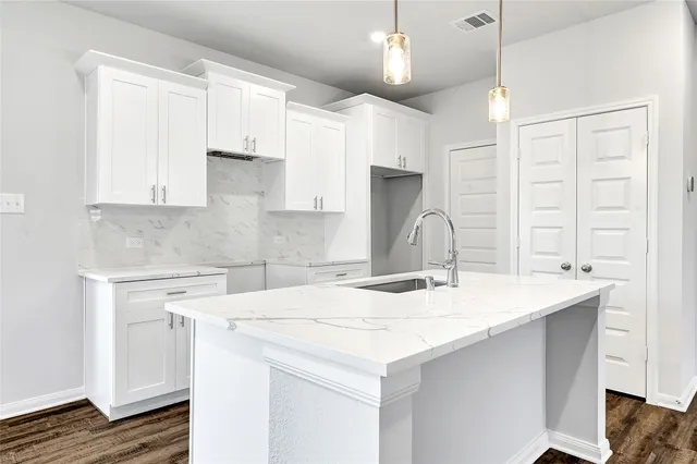 a kitchen with a sink a stove a refrigerator and cabinets