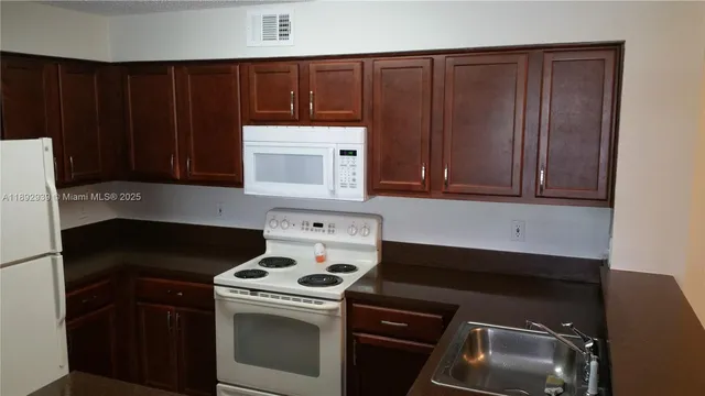 a kitchen with granite countertop a stove and a microwave