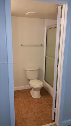 a white toilet sitting next to a shower