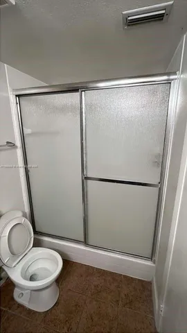 a bathroom with a toilet and a mirror