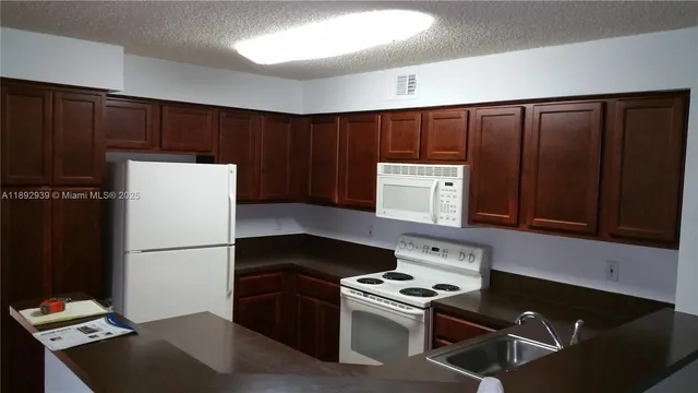a kitchen with a refrigerator and a stove top oven