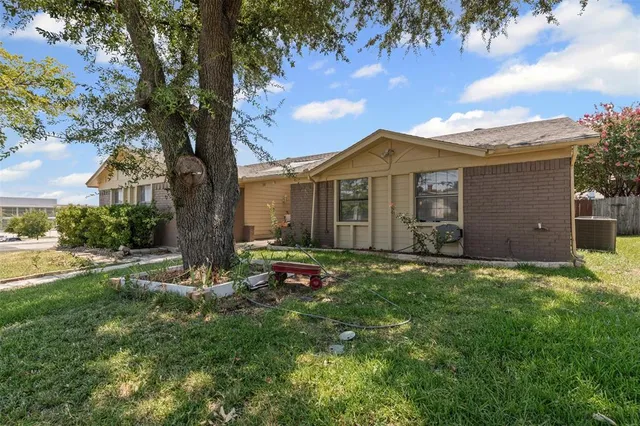 a view of a house with backyard and a tree