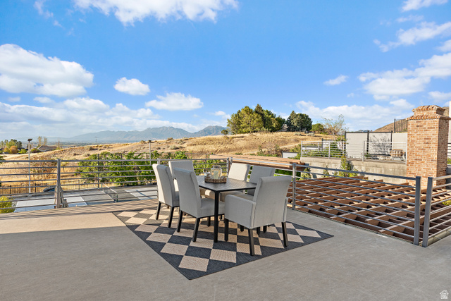 912 North Loafer Canyon Road Elk Ridge, UT 84651 - Photo 51 of 98 Expansive outdoor terrace with concrete flooring, metal railing, and a brick chimney structure