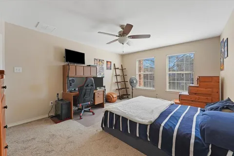 a bedroom with a bed lamp and a potted plant