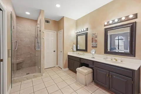 a spacious bathroom with a double vanity sink a mirror and a bathtub