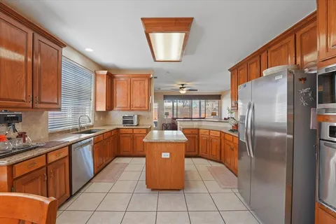 a kitchen with stainless steel appliances granite countertop a sink stove and refrigerator