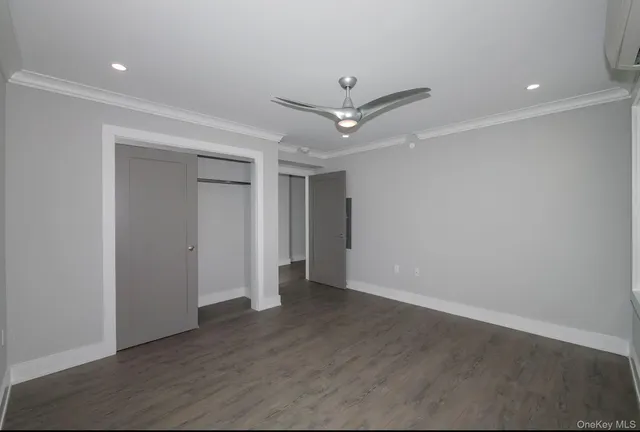 an empty room with wooden floor and ceiling fan