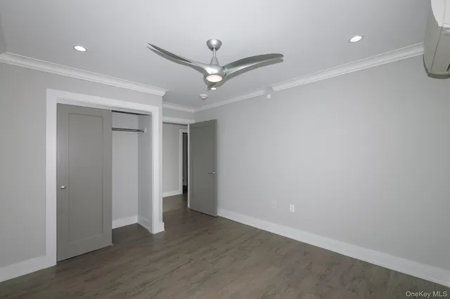 an empty room with wooden floor and ceiling fan