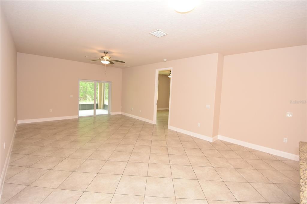 16 Serbian Bellflower Trail, Unit A Palm Coast, FL 32164 - Photo 11 of 41 an empty room with a ceiling fan and glass door