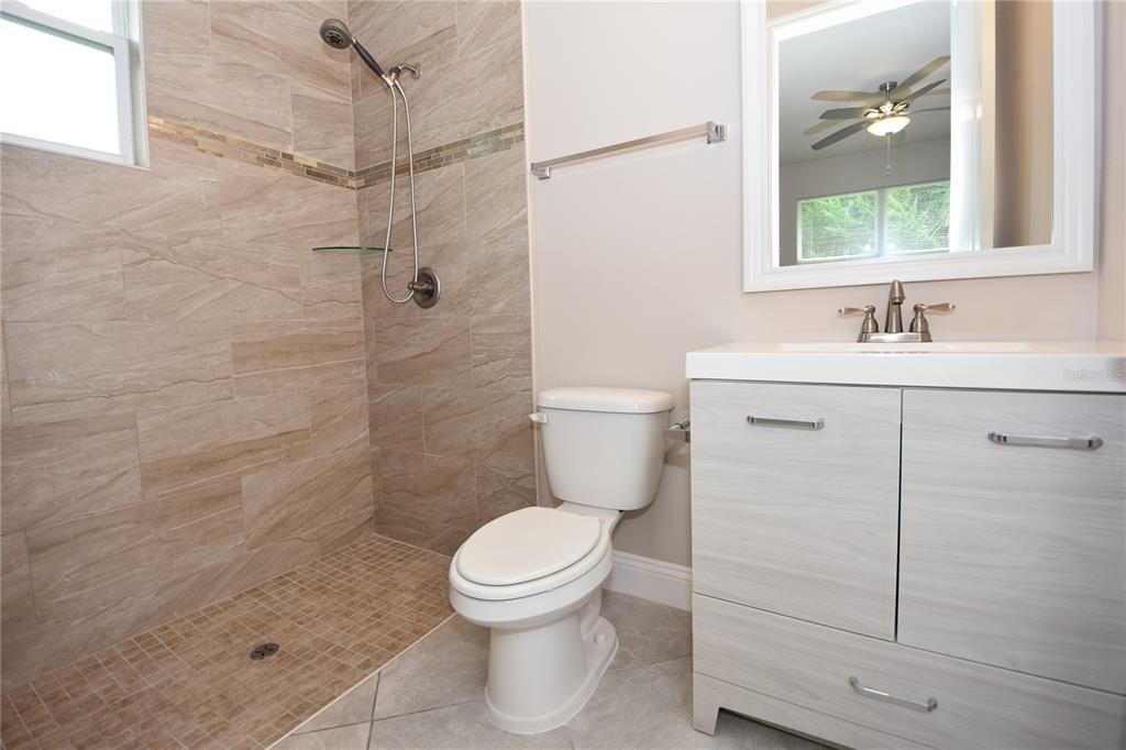 16 Serbian Bellflower Trail, Unit A Palm Coast, FL 32164 - Photo 22 of 41 a bathroom with a toilet sink vanity and granite