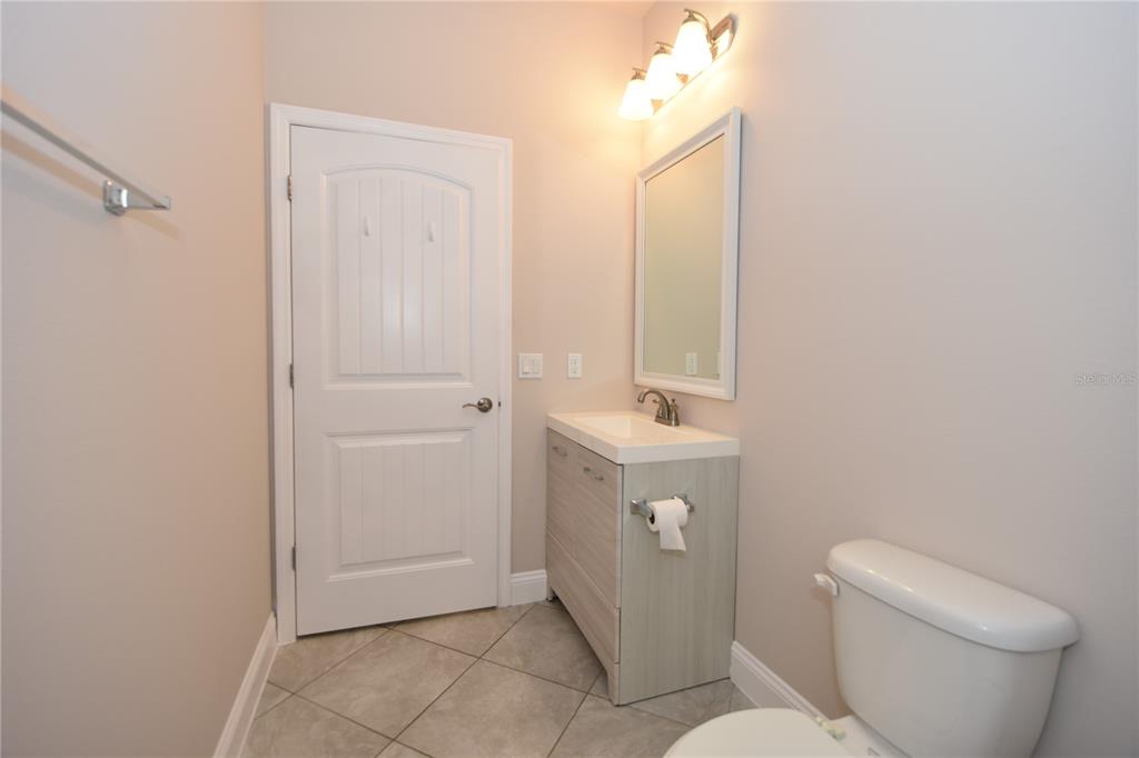 16 Serbian Bellflower Trail, Unit A Palm Coast, FL 32164 - Photo 39 of 41 a bathroom with a toilet sink and mirror