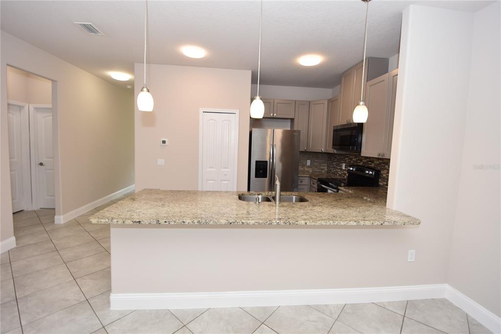 16 Serbian Bellflower Trail, Unit A Palm Coast, FL 32164 - Photo 5 of 41 a bathroom with a granite countertop sink a mirror and a shower