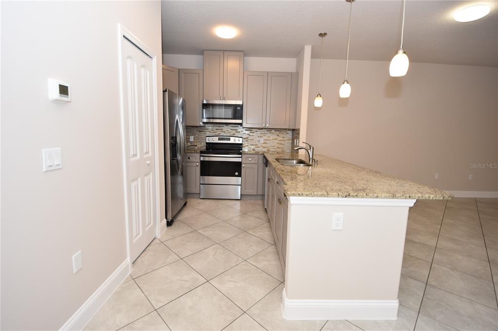 16 Serbian Bellflower Trail, Unit A Palm Coast, FL 32164 - Photo 6 of 41 a kitchen with kitchen island granite countertop a stove a sink and a refrigerator