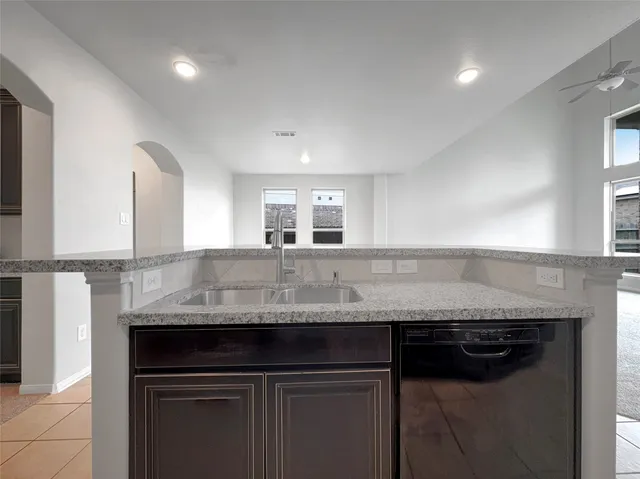 a kitchen with granite countertop a sink and cabinets