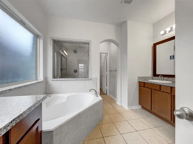 a spacious bathroom with a granite countertop sink and a mirror