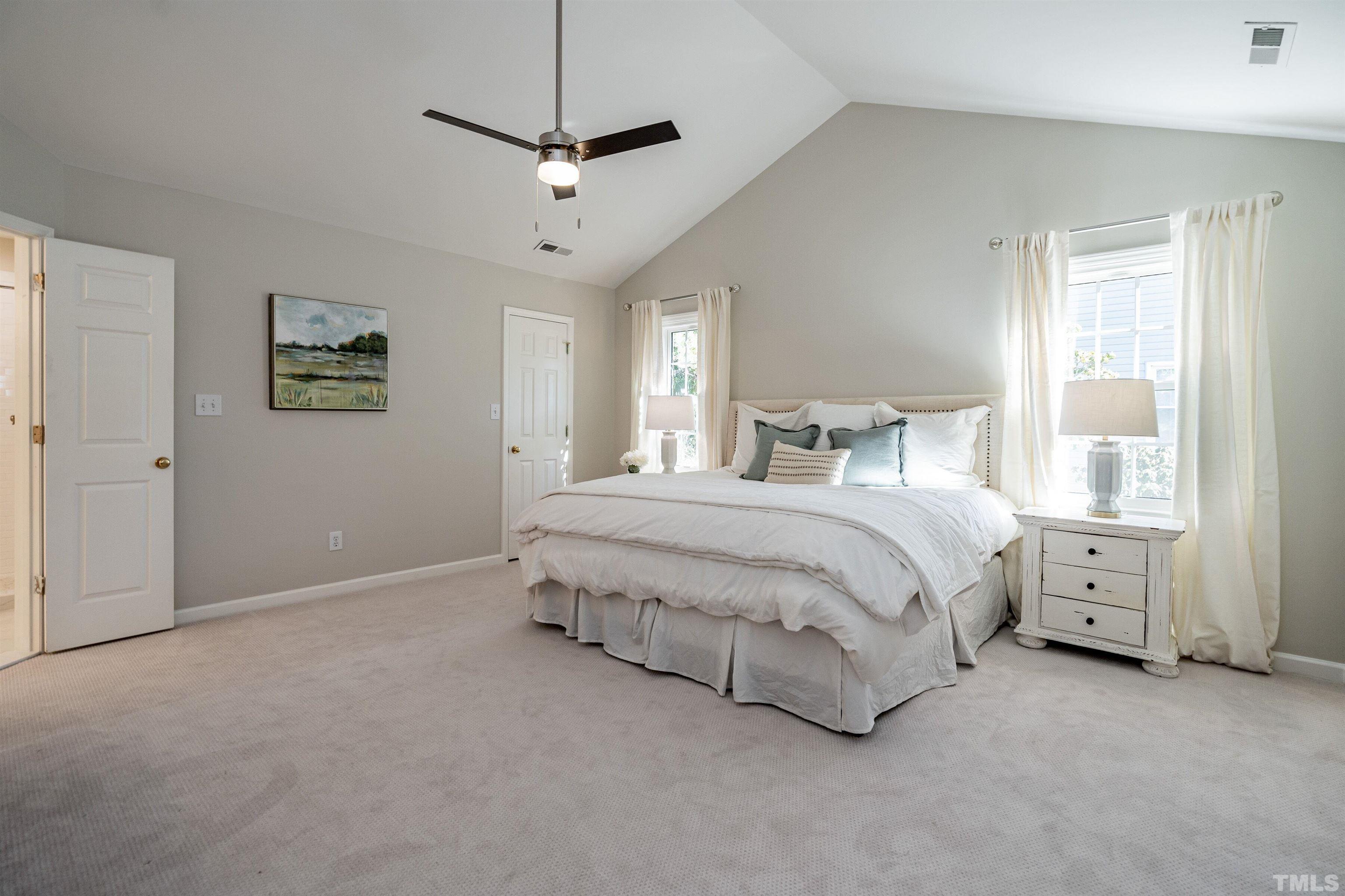 2420 Havershire Drive Raleigh, NC 27613 - Photo 14 of 25 a spacious bedroom with a bed and a chandelier