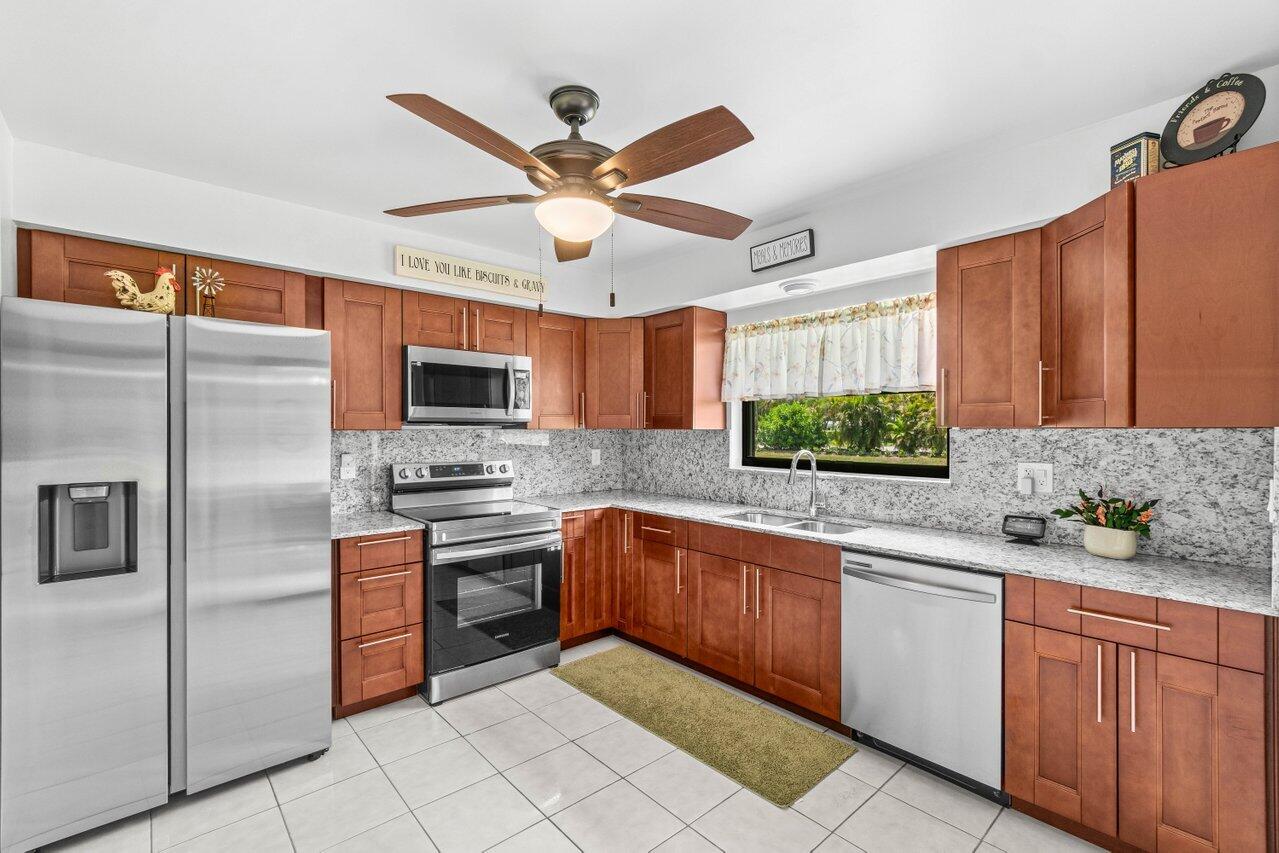 4260 Mango Tree Court, Unit B Boynton Beach, FL 33436 - Photo 1 of 35 a kitchen with stainless steel appliances granite countertop a sink a stove and a refrigerator