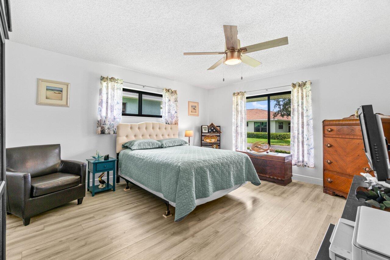 4260 Mango Tree Court, Unit B Boynton Beach, FL 33436 - Photo 12 of 35 a bedroom with a bed and wooden floor