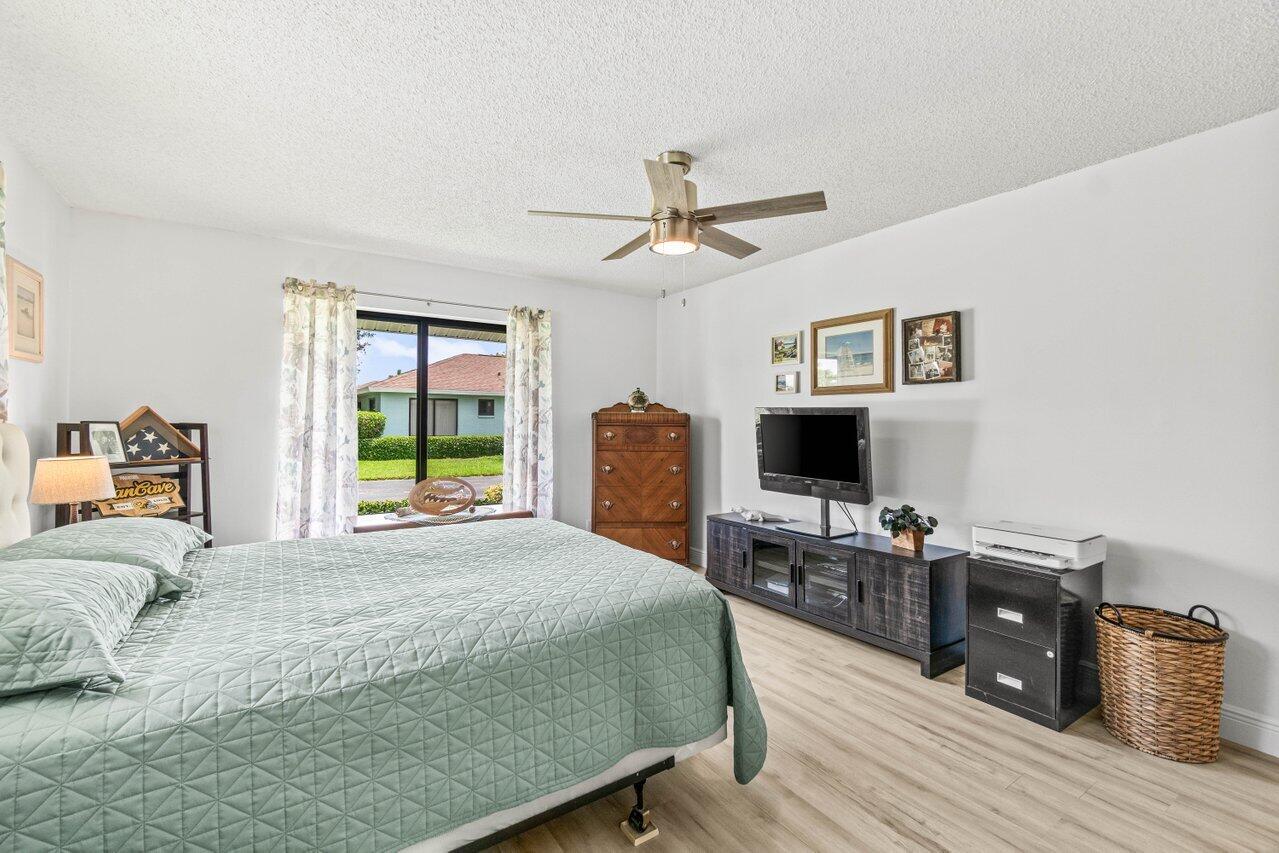 4260 Mango Tree Court, Unit B Boynton Beach, FL 33436 - Photo 13 of 35 a bedroom with a bed wooden floor and a window
