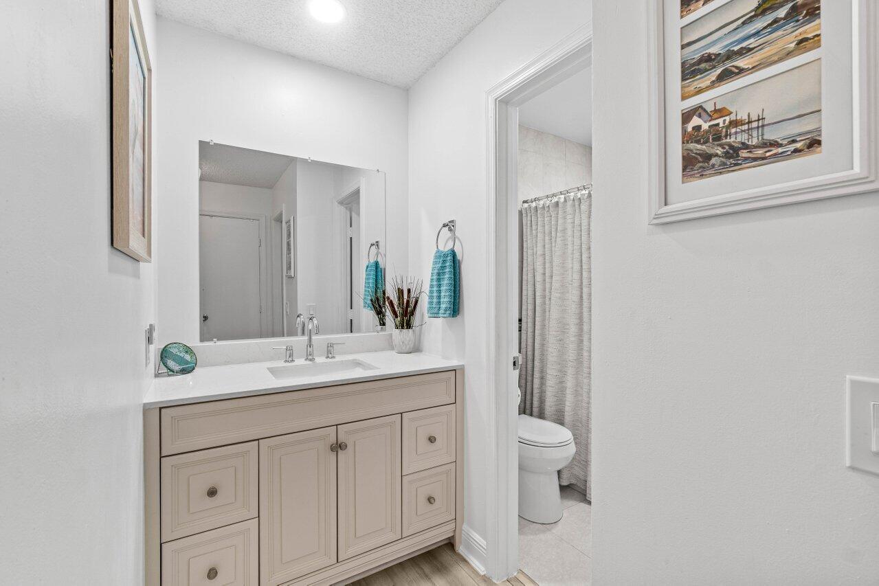 4260 Mango Tree Court, Unit B Boynton Beach, FL 33436 - Photo 14 of 35 a spacious bathroom with a granite countertop sink toilet and mirror
