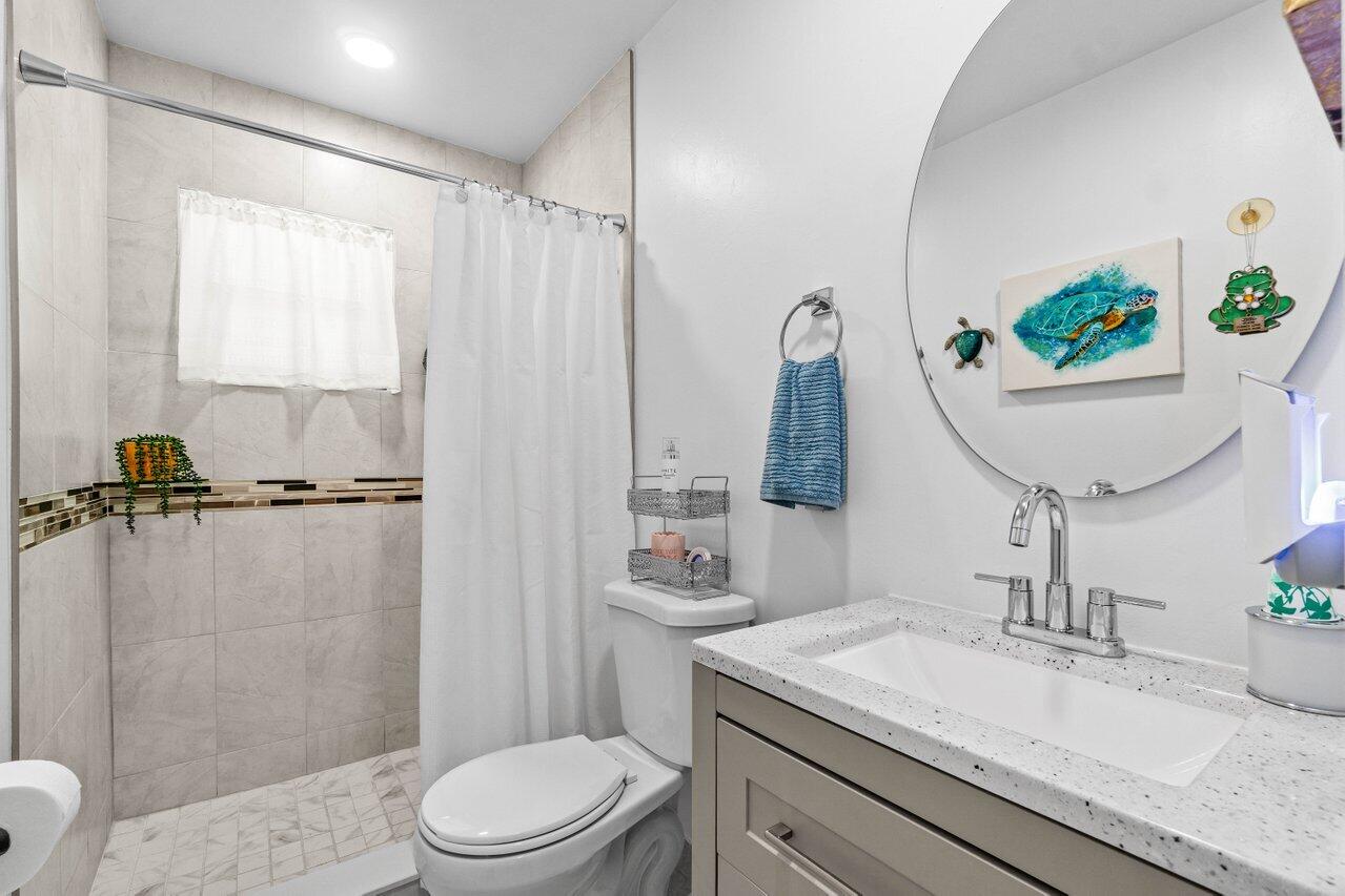 4260 Mango Tree Court, Unit B Boynton Beach, FL 33436 - Photo 17 of 35 a bathroom with a granite countertop sink mirror vanity and toilet