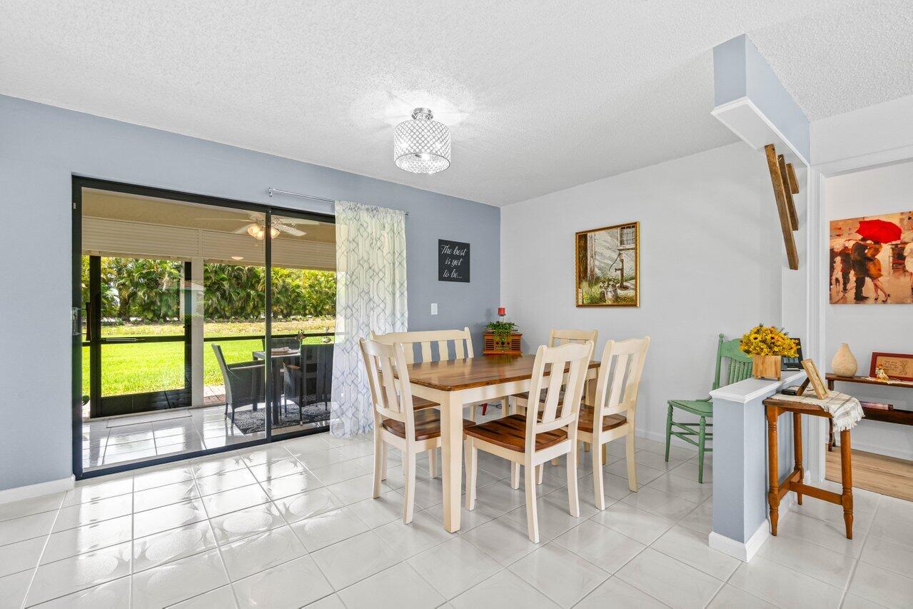 4260 Mango Tree Court, Unit B Boynton Beach, FL 33436 - Photo 7 of 35 a view of a dining room with furniture a chandelier and a large window