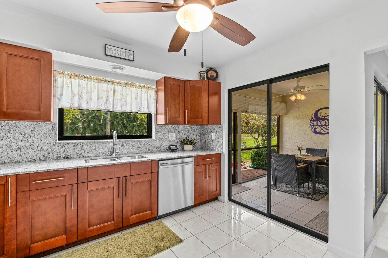4260 Mango Tree Court, Unit B Boynton Beach, FL 33436 - Photo 9 of 35 a kitchen with stainless steel appliances granite countertop a stove a sink and a refrigerator