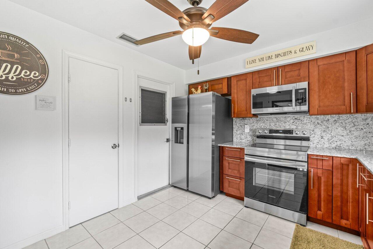 4260 Mango Tree Court, Unit B Boynton Beach, FL 33436 - Photo 10 of 35 a kitchen with stainless steel appliances granite countertop a stove and a refrigerator