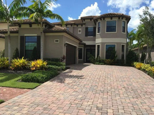 a front view of a house with a yard and potted plants