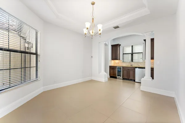 an empty room with chandelier and windows