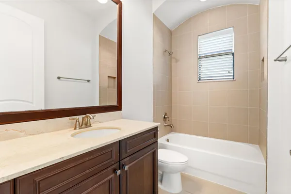 a bathroom with a granite countertop toilet a sink and shower