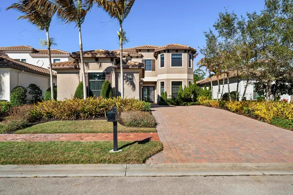 a front view of a house with a yard and potted plants