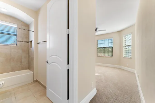 an empty room with windows and ceiling fan