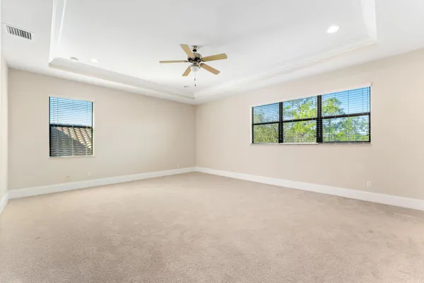 an empty room with windows and ceiling fan